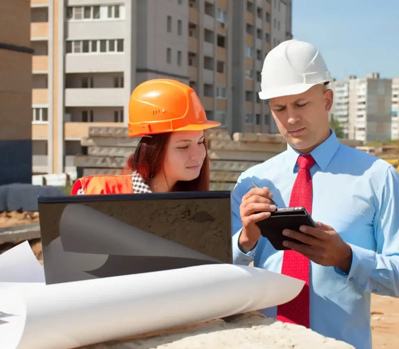 Two architects in front of building site