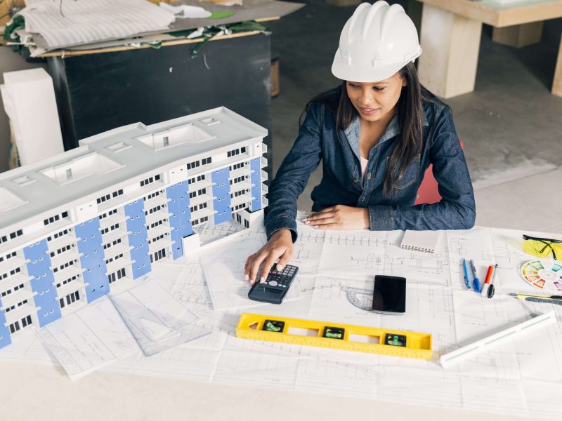african-american-lady-safety-helmet-sitting-near-model-building-min (1)